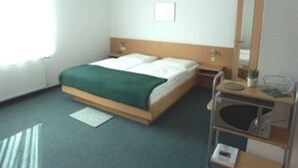 A hotel room with a bed, bedside table, and a mirror. - App. 28 - Apartment house Anne (Binz)