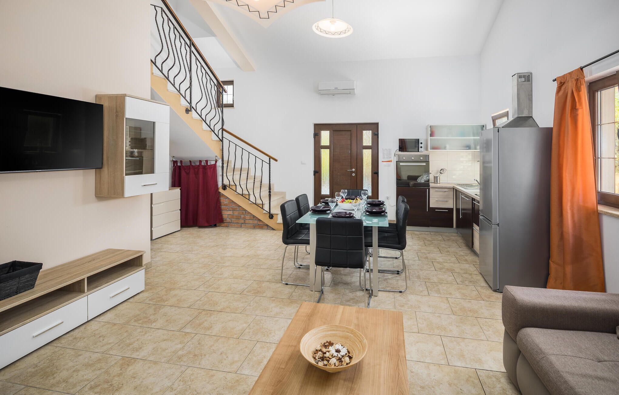 A modern apartment with a dining area, kitchen, and living space.