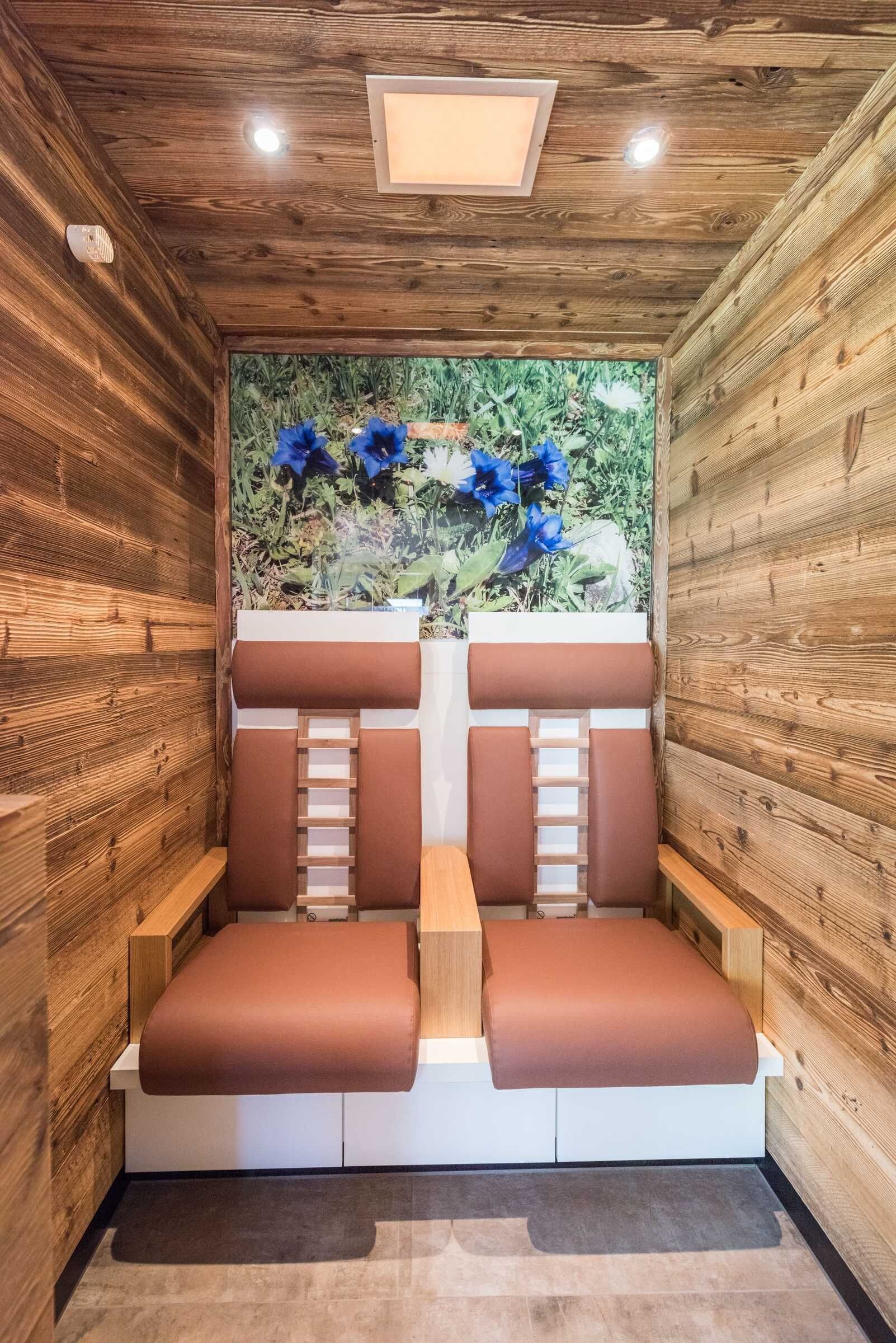 A sauna with wooden walls and a central bench.