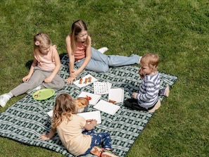 Four children sitting on a checkered blanket outdoors. - Sunnhof - Arnika vacation apartment (Gegend)