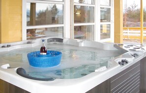 Een bubbelbad met een blauw decoratief element en een fles wijn.