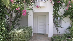 Un bâtiment blanc avec un chemin de pierre menant à une porte.