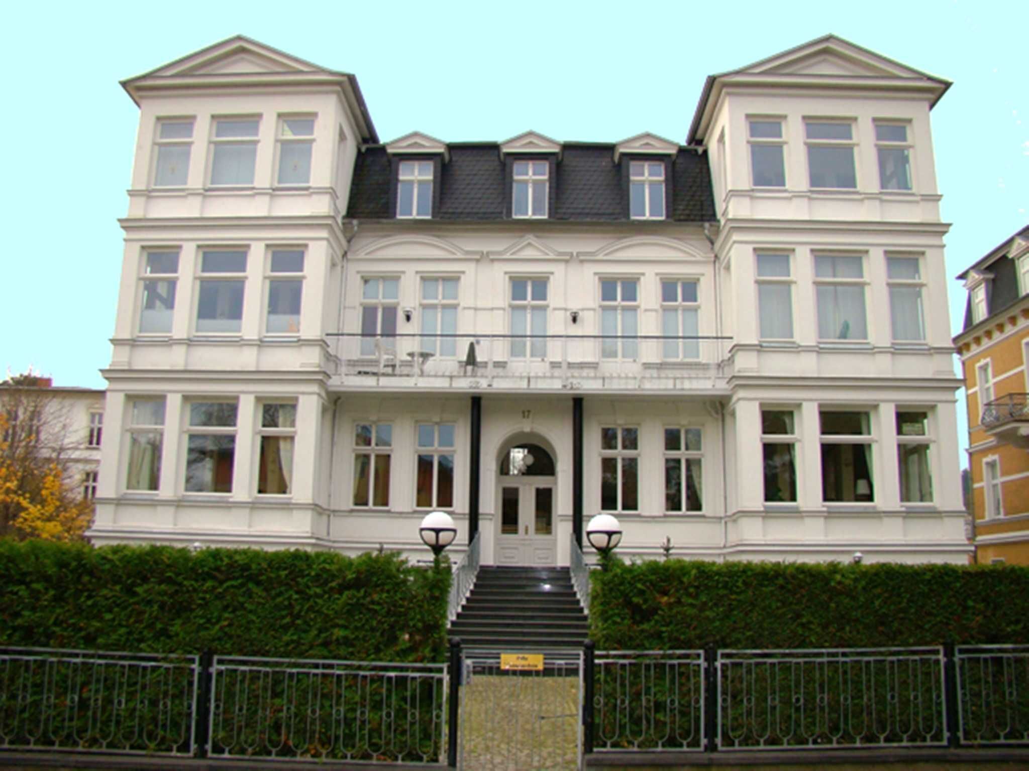 Ein großes, imposantes Gebäude mit einer symmetrischen Fassade, zahlreichen Fenstern und einem zentralen Eingang mit Treppe.