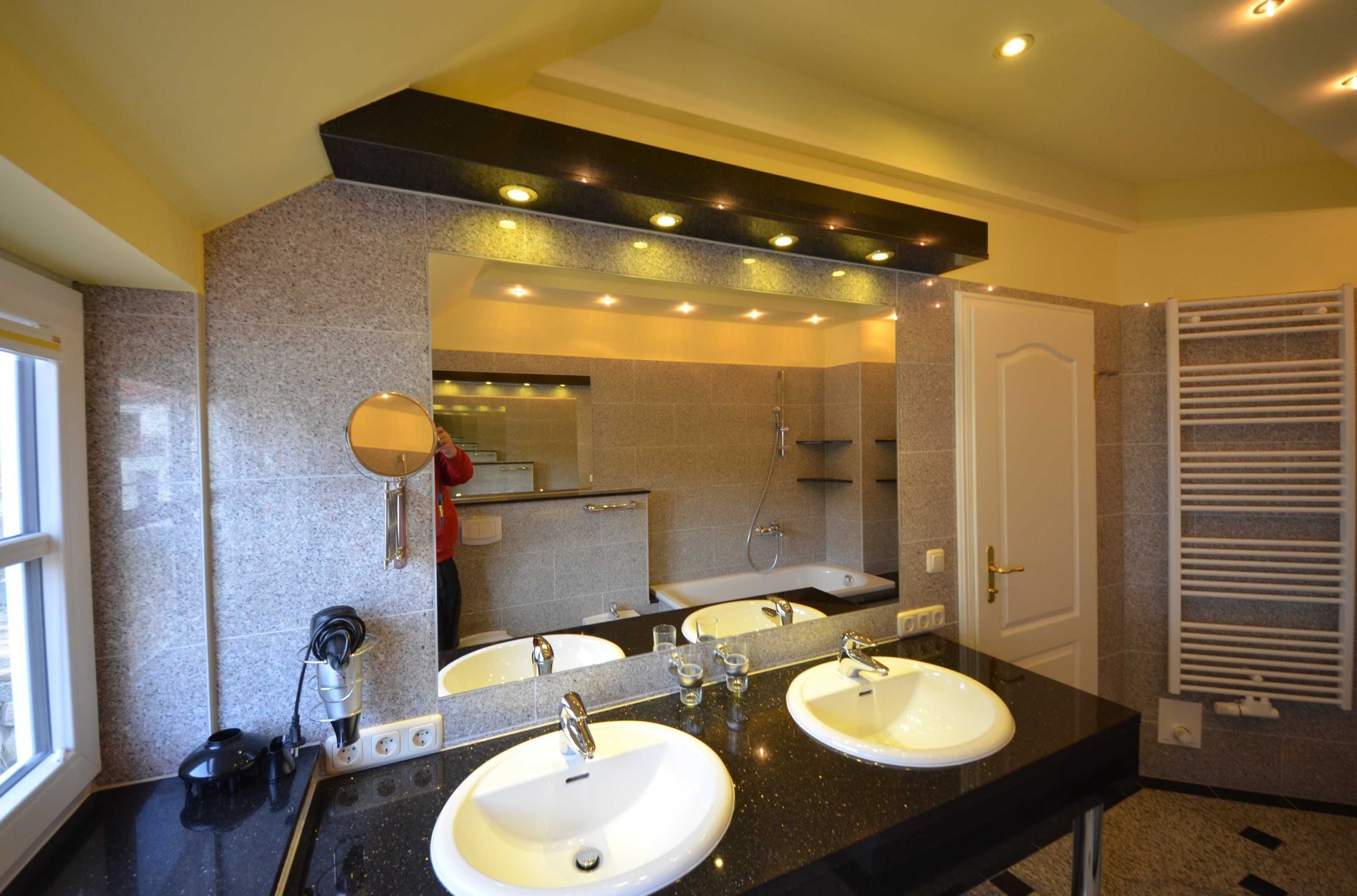 A bathroom with two sinks, a large mirror, and a towel rack.