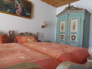 A bedroom with a bed, a wardrobe, a painting, and a nightstand. - Double Room 2 - Haus Bamberger (Fischbachau)