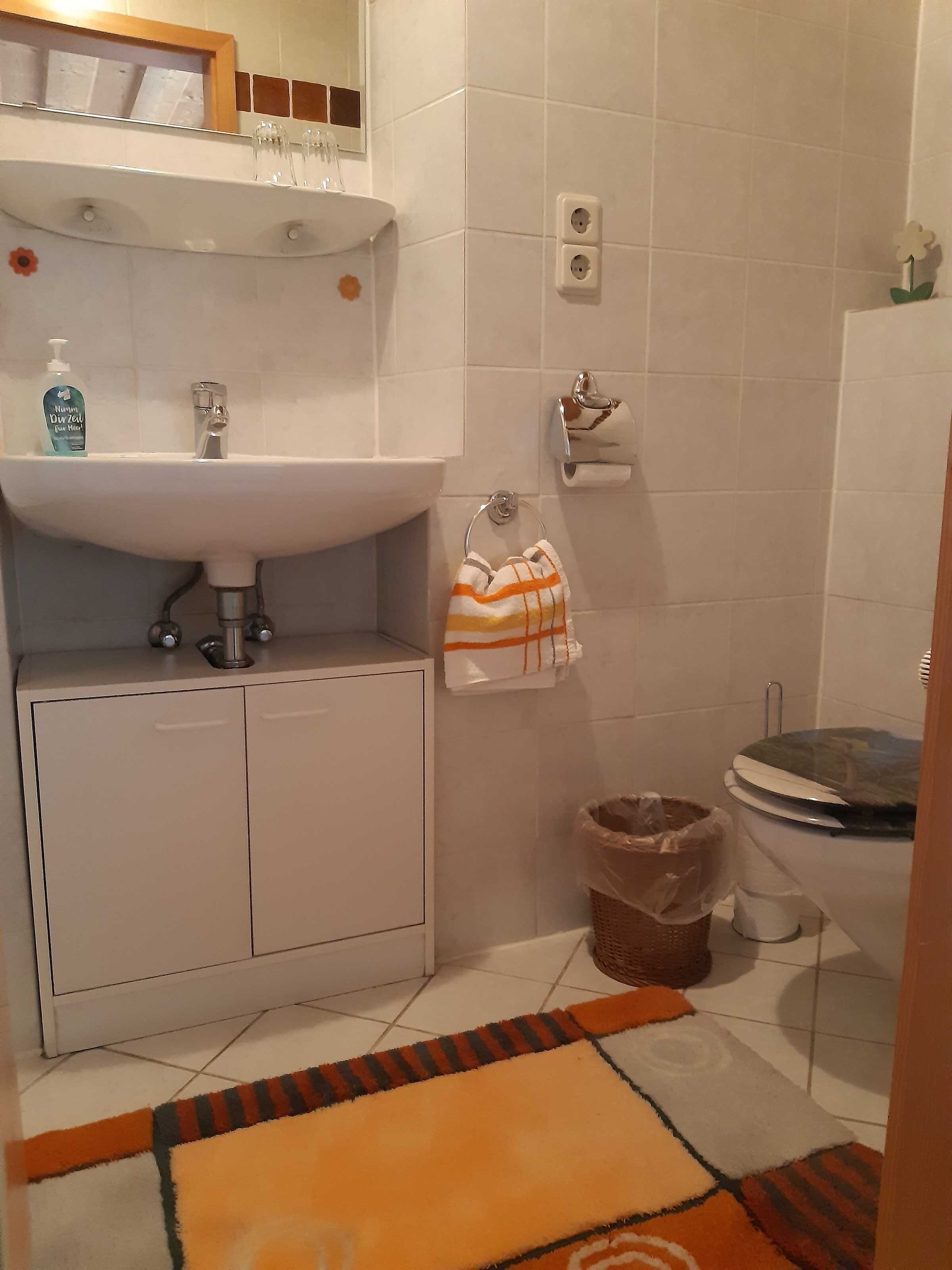 Ein Badezimmer mit Waschbecken, Toilette und Mülleimer.