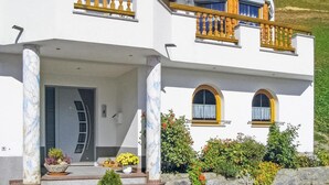 A two-story house with a white facade, wooden balconies, and a covered porch. - Ferienwohnung mit top Ausblick (Kappl)