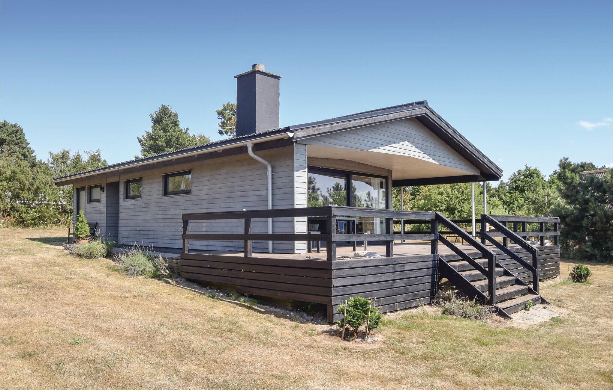 Une maison moderne de plain-pied, dotée d’un porche abrité et d’un escalier menant à l’entrée.