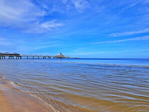 A pier extending into calm waters with clear skies.