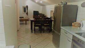 A compact kitchen with a refrigerator, stove, and dining area.
