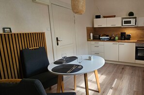 Ett modernt kök med vita skåp, en mikrovågsugn och en kaffebryggare.