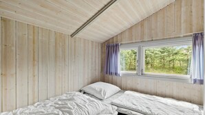 A small, single-bed room with wooden walls and a window with curtains. - Gorgeous home in Fjerritslev with sauna (Fjerritslev)