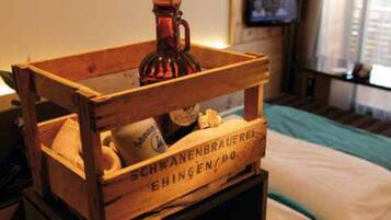 Une caisse en bois contenant une bouteille et un coussin, le tout étiqueté « SCHWANENBRAUEREI EHINGEN/DO. »