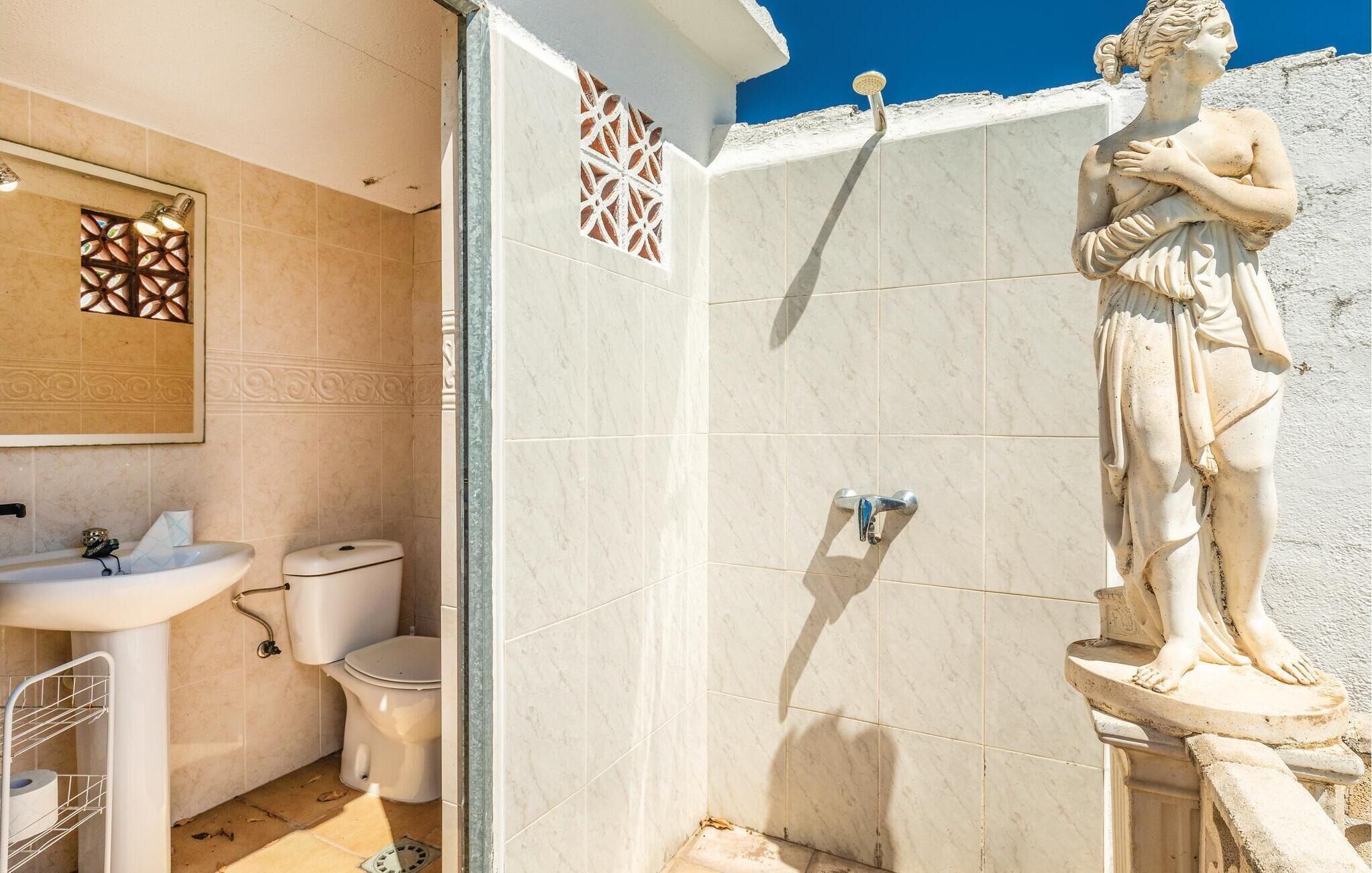 Un bagno con doccia, toilette, lavandino e piastrelle decorative.