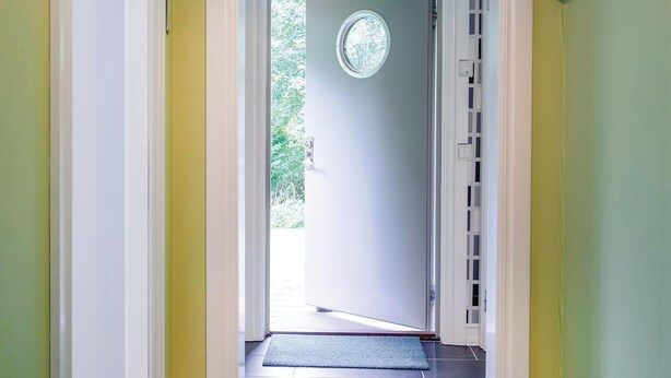 A hallway leading to a door with a circular window and a doorbell. - 2 bedroom nice home in ätran (Ätran)