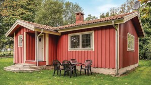 A small red house with a chimney, a porch with steps, and a table with chairs outside. - 2 bedroom nice home in ätran (Ätran)