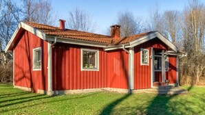 A red wooden house with a tiled roof, a chimney, and a front door. - 2 bedroom nice home in ätran (Ätran)