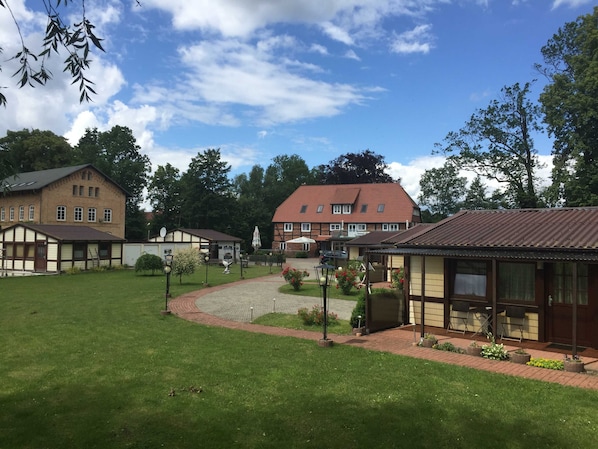 A residential area with multiple houses, a paved courtyard, and a large building with a red roof.
