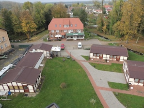 A traditional building with a red roof, multiple windows, and a paved courtyard. - 03 AP - Island Hotel Dobbertin (Dobbertin)
