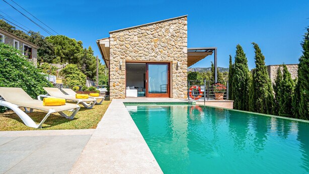 A modern stone building with a pool, sun loungers, and a clear blue sky. - Stunning home in Mancor de la Vall (Mancor de la Vall)