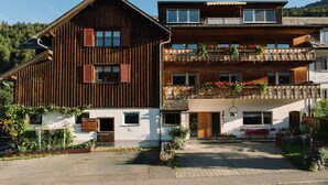 A two-story wooden building with a balcony and flower boxes.