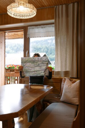 Un interior de madera con una mesa de comedor, un banco y un mapa sostenido.