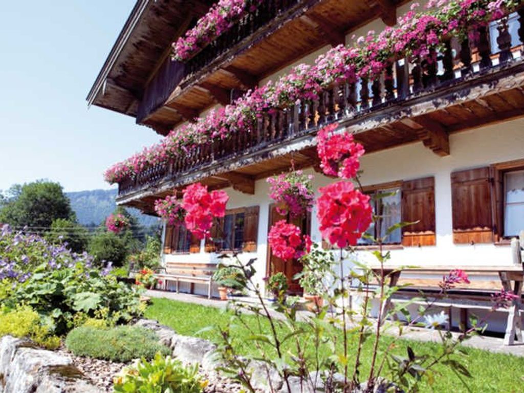 Una cabaña tradicional con balcones de madera y macetas con flores.