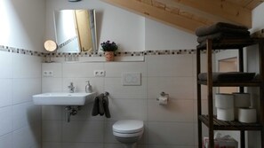 Een badkamer met een wastafel, toilet en spiegel.
