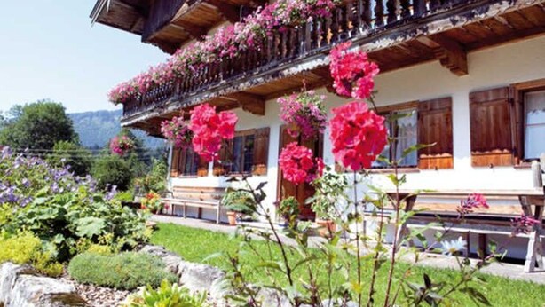 A traditional chalet with wooden balconies and flower boxes. - Apartment Blauberg - Böcklhof, Kreuth-Brunnbichl (Kreuth)