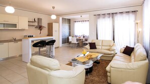 Una sala de estar moderna con un conjunto de sofá, una mesa de centro y un comedor con mesa y sillas.