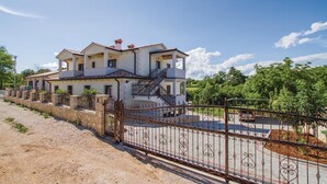 Una casa de dos pisos con entrada protegida y camino de entrada pavimentado.