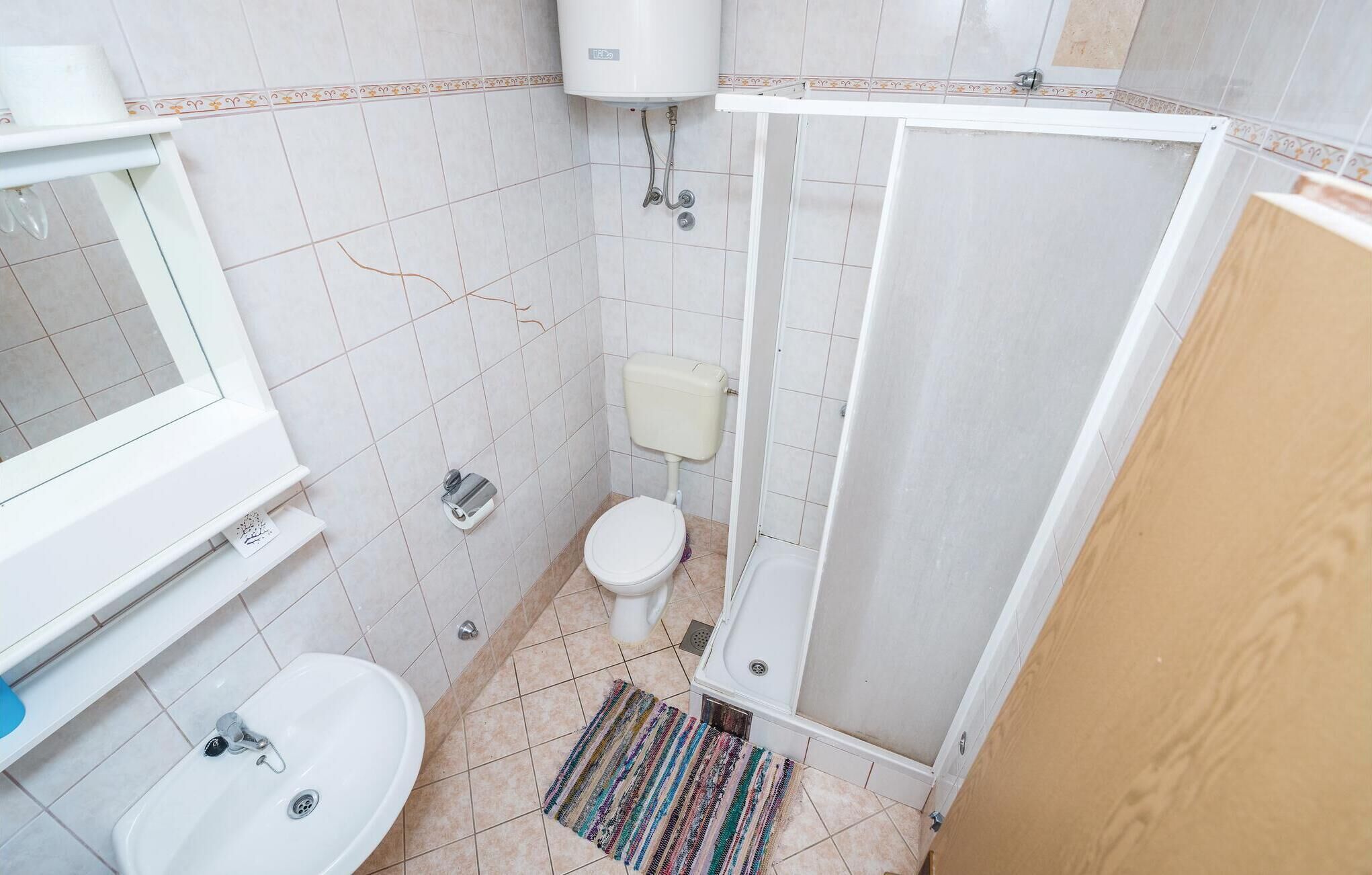 Ein kleines Badezimmer mit Toilette, Waschbecken und Dusche.