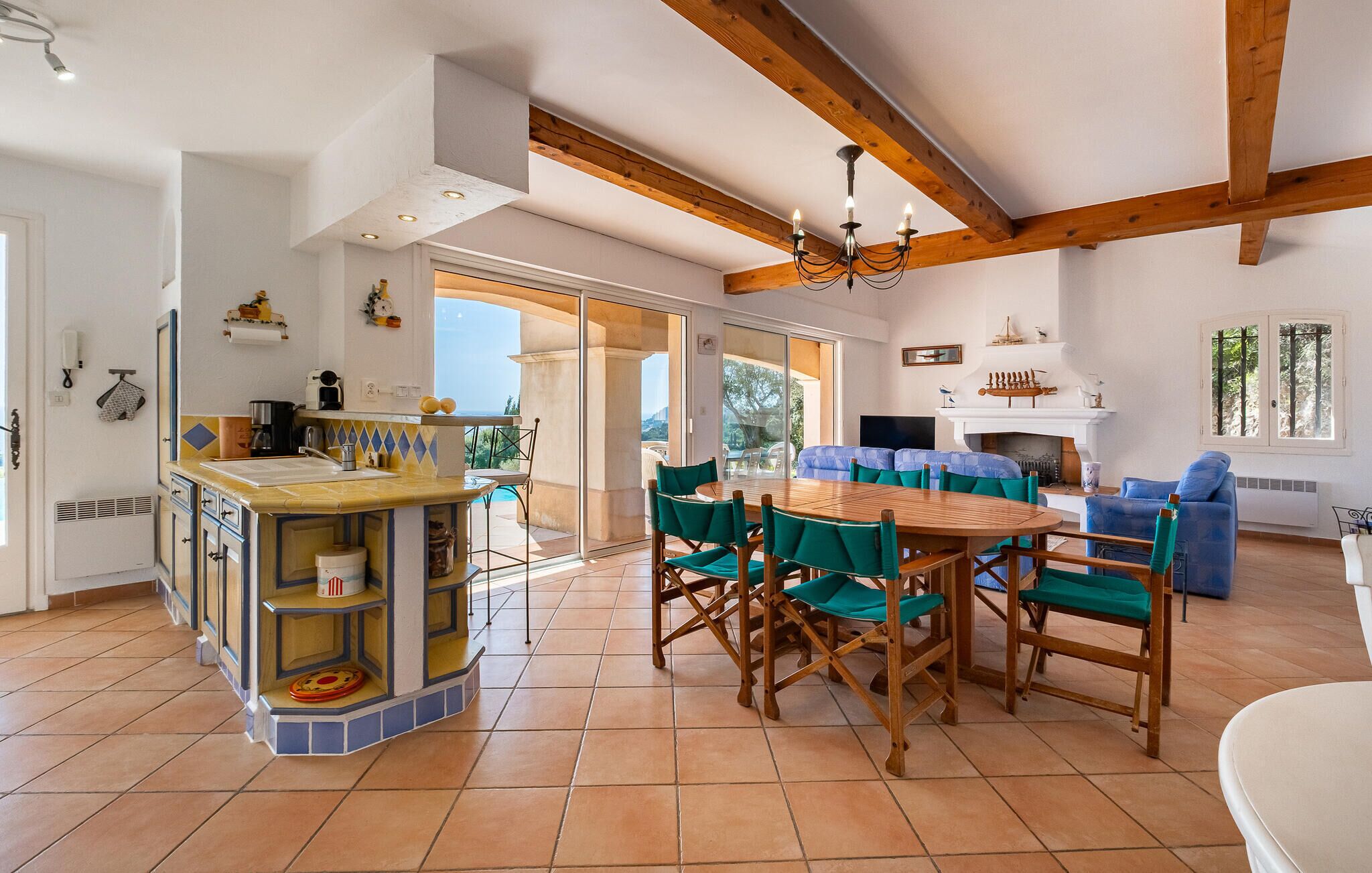Amplia sala de estar con mesa y sillas de madera, chimenea y balcón con vistas.