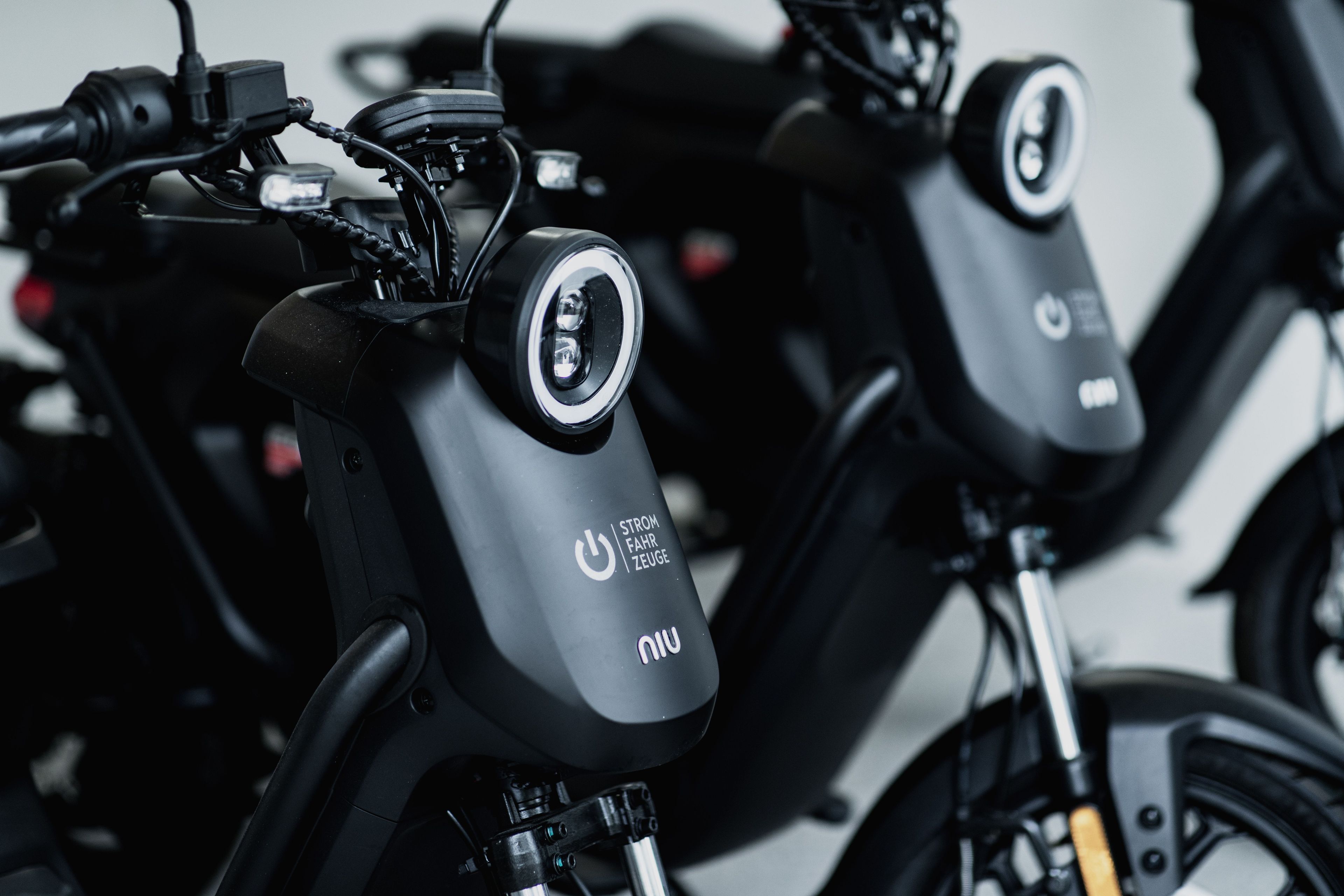 Een close-up van elektrische scooters met een opvallende aan-uitknop en merklogo.
