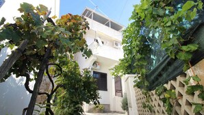 Un edificio de dos pisos con un balcón, rodeado de viñedos.
