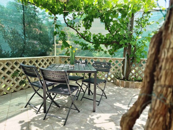 Enjoy dining or socializing in this patio area with a table and chairs.