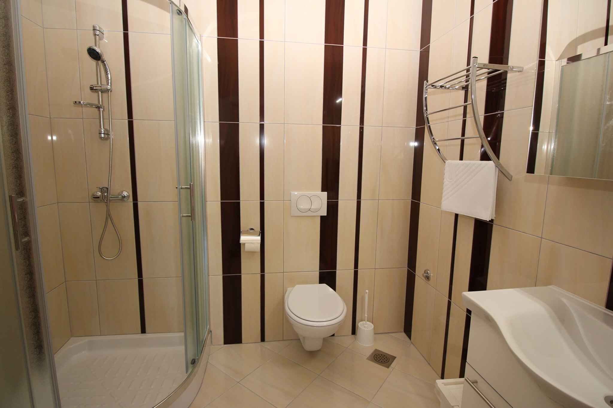 Une salle de bain moderne avec une douche à parois de verre, des toilettes et une baignoire.