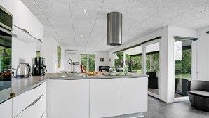 A modern kitchen with a central island, stainless steel appliances, and a view of the outdoors. - Amazing home in Bogense with WiFi (Bogense)