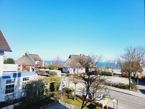 Ein Küstenwohngebiet mit Häusern, blauem Himmel und Blick aufs Meer.