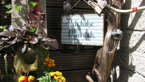 Maalaismainen puinen rakennelma, jossa on roikkuva kyltti, jossa lukee: ”Ich habe Meerweh.”