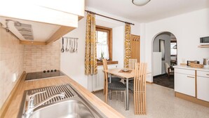 Eine moderne Küche mit Holzausziehtisch, Spüle und Essbereich mit Tisch und Stühlen.