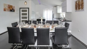 A modern dining area with a glass table set for four, surrounded by black chairs. - Stunning home in Rumin with sauna (Rumin)