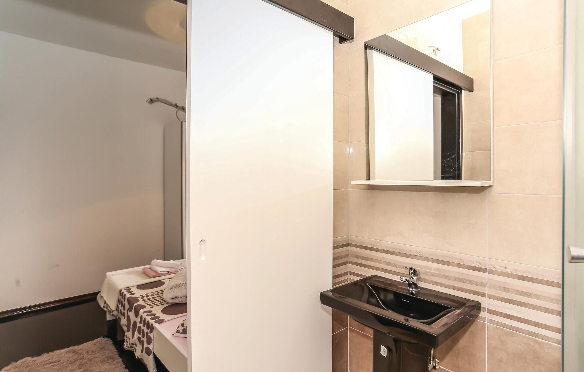 Une salle de bain équipée d’un lavabo, d’un miroir et d’un porte-serviettes.