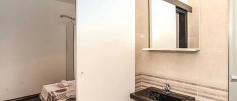 Une salle de bain équipée d’un lavabo, d’un miroir et d’un porte-serviettes.