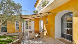A patio with a table and chairs, a covered area, and a door with a window.