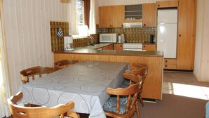 A compact kitchen with wooden cabinets, a microwave, a stove, and a refrigerator. - Amazing home in Rømø with kitchen (Rømø)