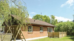 A brick house with a tiled roof, a wooden ladder, and a wooden gate in a grassy yard. - Amazing home in Rømø with kitchen (Rømø)