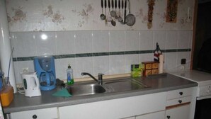 A kitchen with a sink, a coffee maker, a dish soap bottle, and a box of tissues. - Double room - online - Gästezimmer Wolter (Lutherstadt Wittenberg)