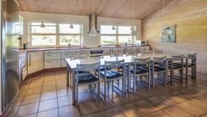 A modern kitchen with a central island, ample natural light, and a dining area with chairs. - Cozy home in Spøttrup with sauna (Spøttrup)