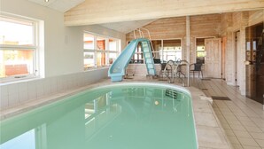 An indoor swimming pool with a blue slide, wooden walls, and a tiled floor. - Cozy home in Spøttrup with sauna (Spøttrup)